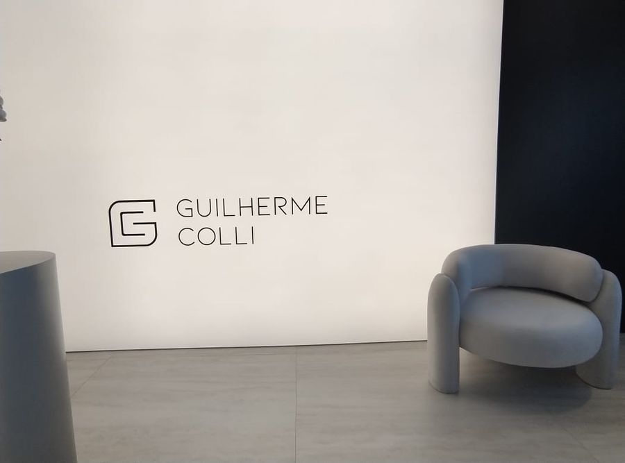 Logotipo Guilherme Colli aplicado em parede branca de recepção